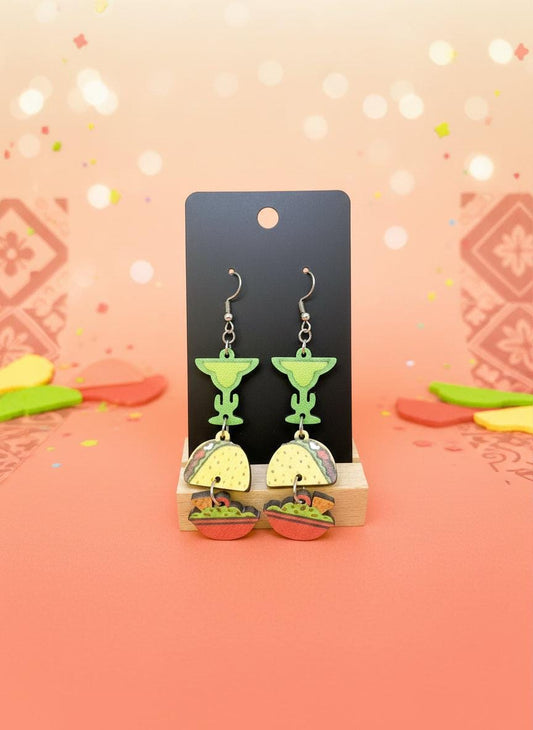 Taco and margarita earrings on a black card with a white background