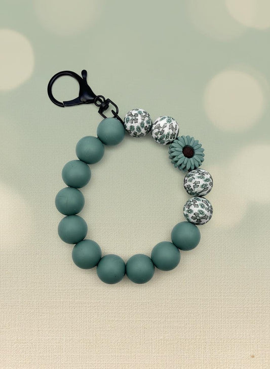 Teal beaded bracelet with decorative beads on a white background