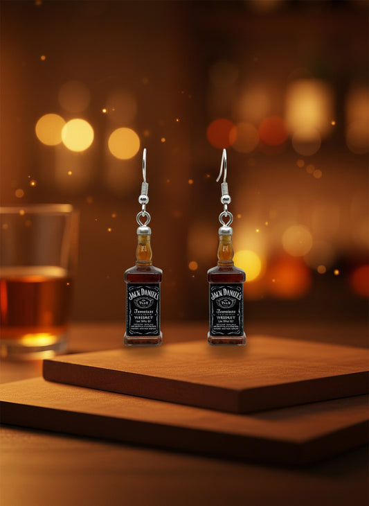Jack Daniel's bottle-shaped earrings on a black card with a wooden stand against a white background