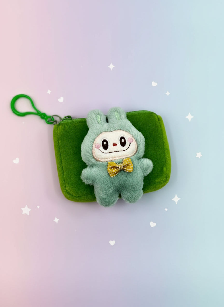 Plush toy in a green outfit with a yellow bow tie on a green pouch against a white background