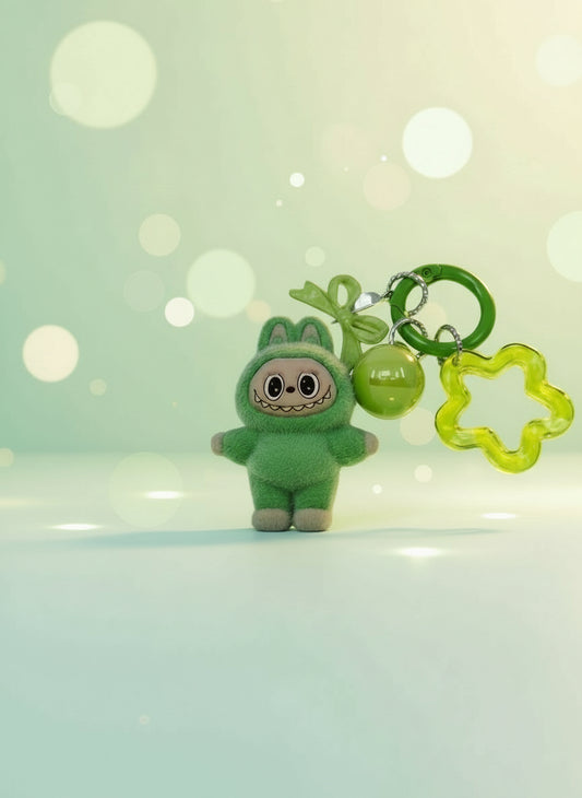 Green plush keychain with a small ball and star-shaped clip on a light gray background