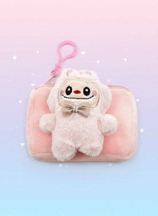 Pink plush toy with a face on a pink pouch against a white background