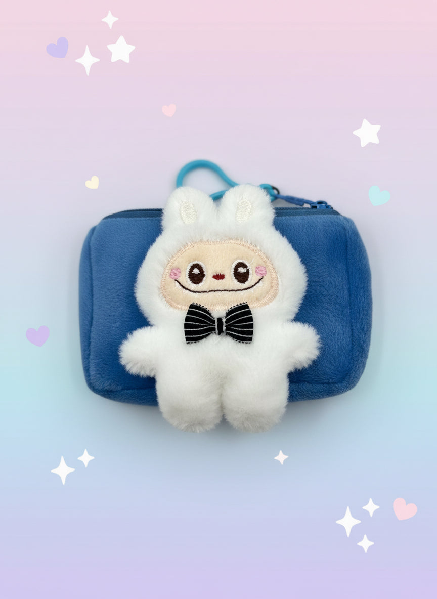 White plush toy with a bow tie on a blue pouch against a light gray background
