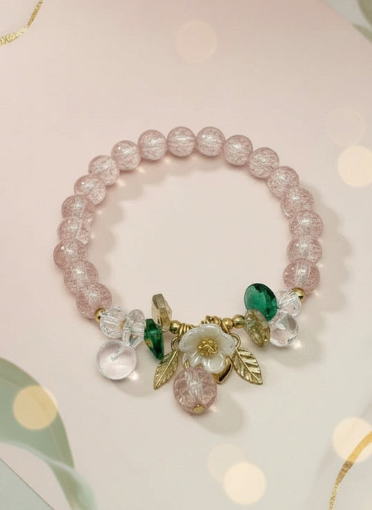 Bracelet with pink beads and charms on a white background