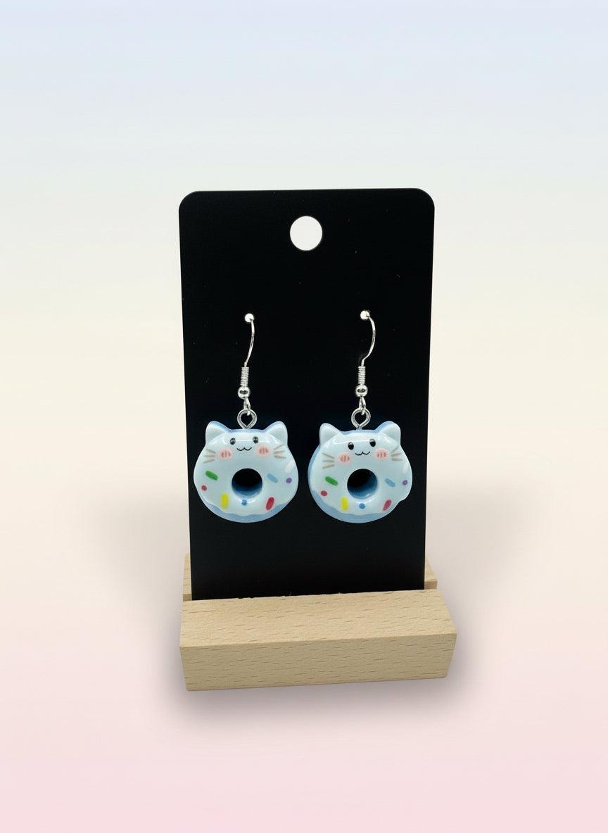 Cute Animal Donut Earrings featuring adorable cat designs with blue icing and colorful sprinkles on display.