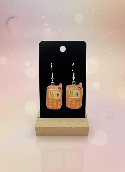 Adorable Kawaii Phone Earrings displayed on a wood stand, showcasing cute resin cartoon phone design in pastel colors.
