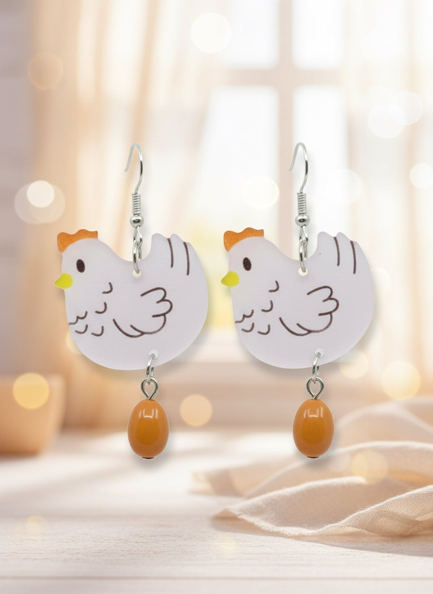 Chicken-shaped earrings on a black card with a wooden stand