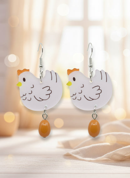 Chicken-shaped earrings on a black card with a wooden stand