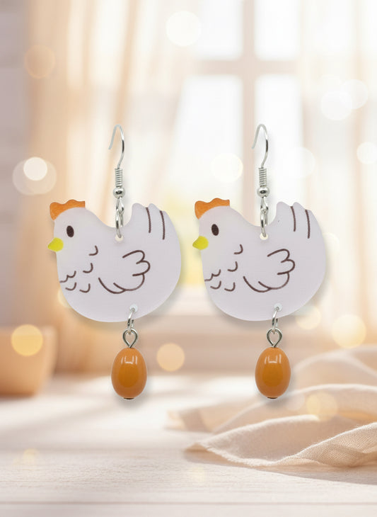 Chicken-shaped earrings on a black card with a wooden stand