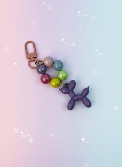 Colorful balloon dog keychain with beads on a light gray background