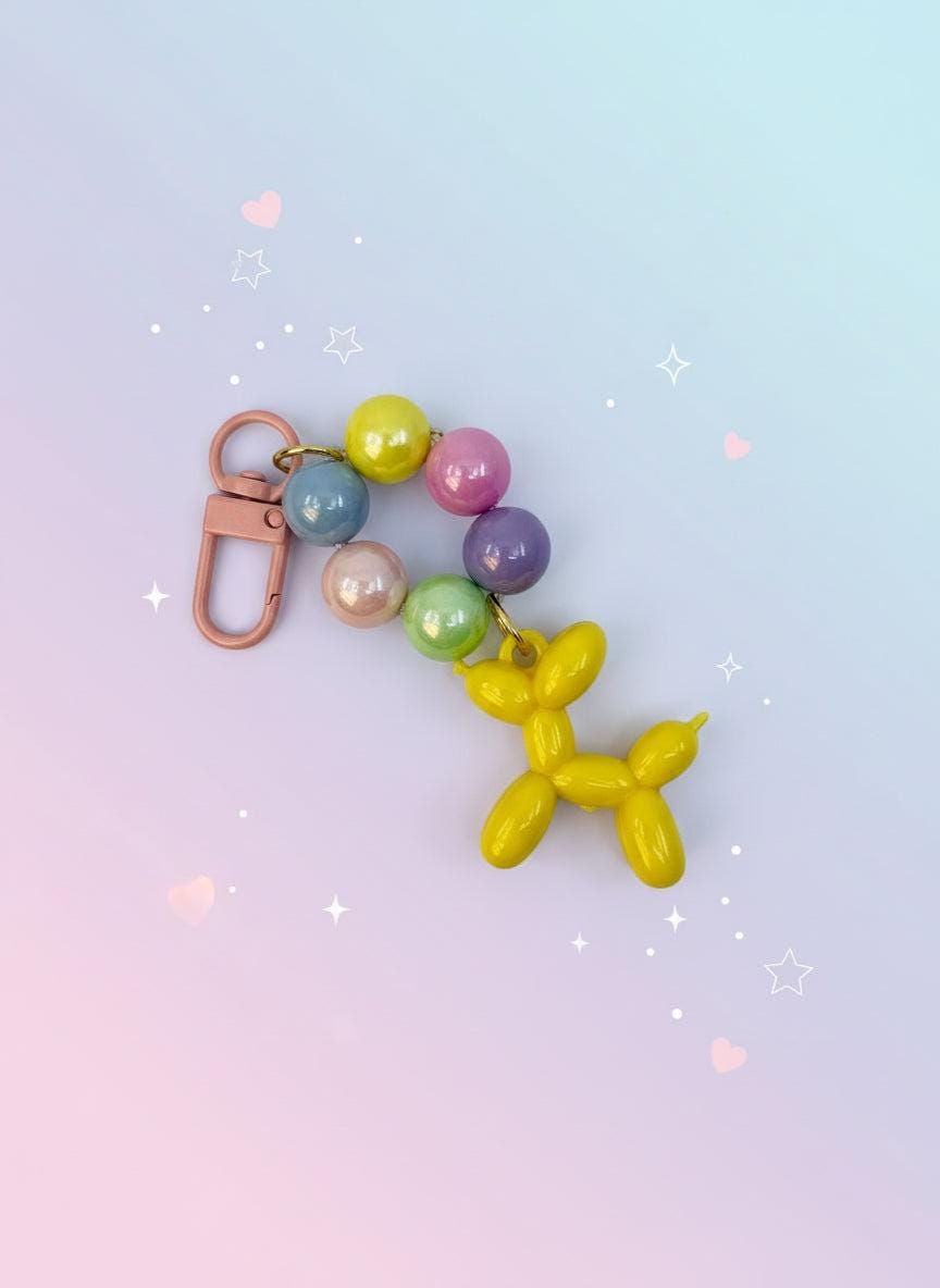 Keychain with colorful beads and a balloon dog charm on a white background