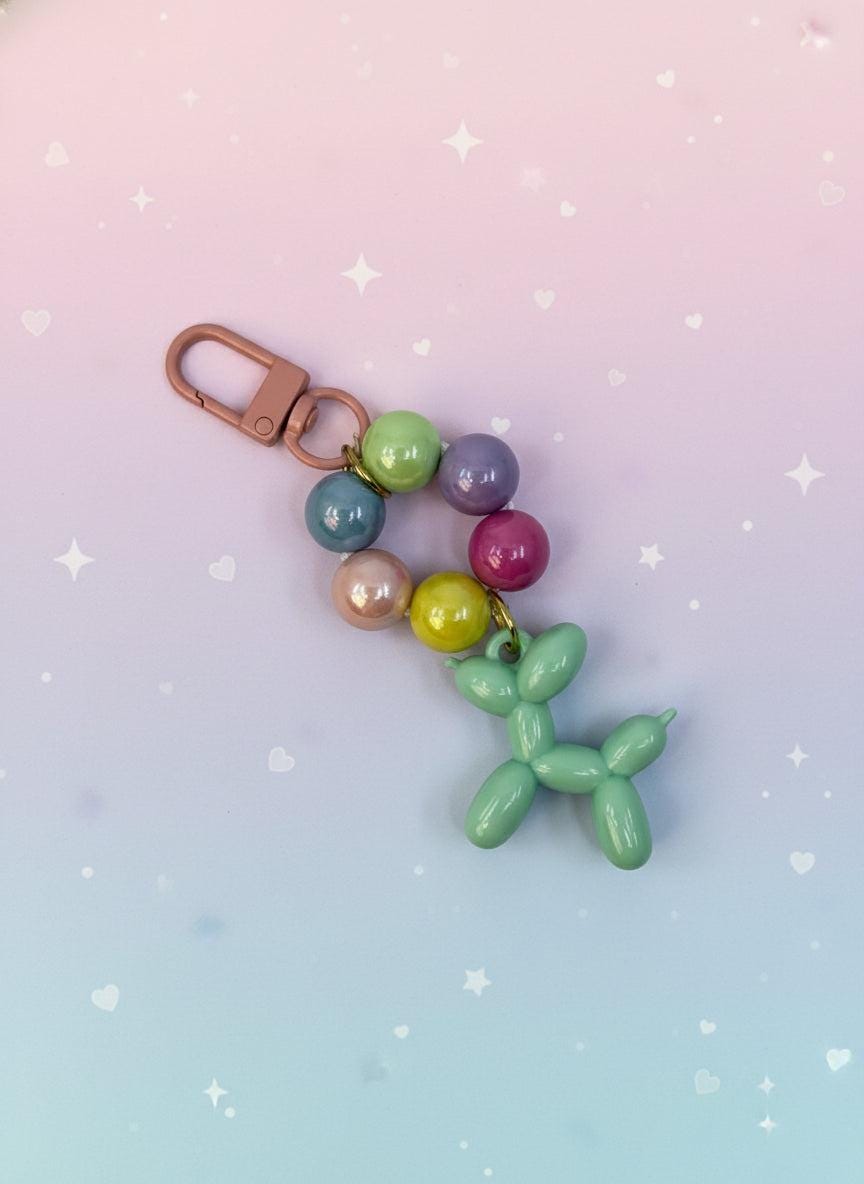 Colorful balloon dog keychain with beads on a white background