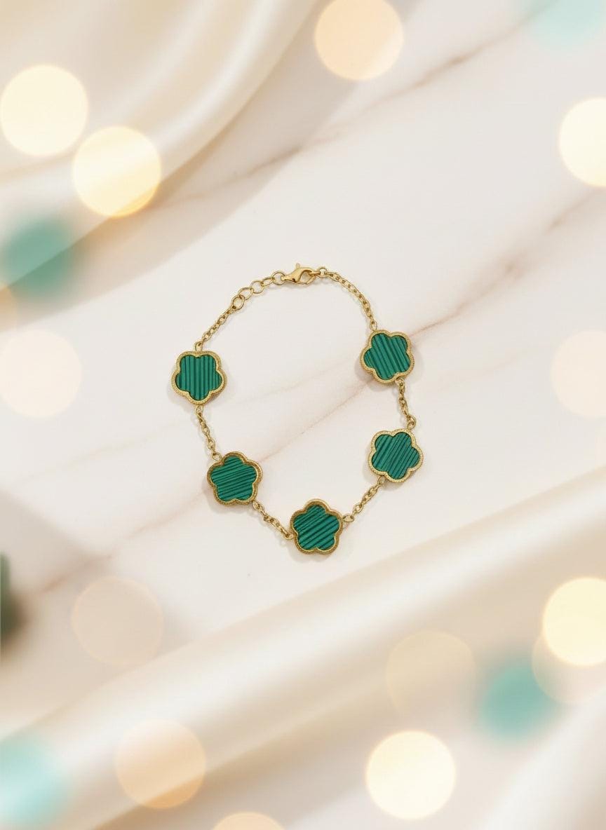 Green necklace with gold chain on a brown card against a white background