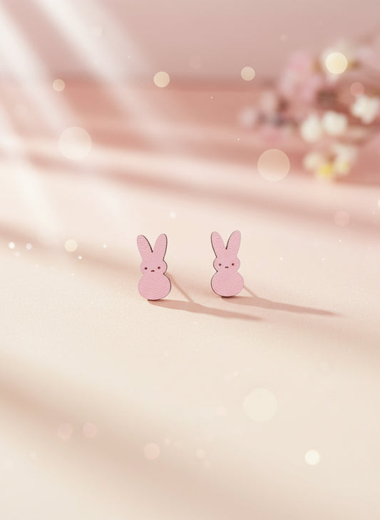 Pink bunny-shaped earrings on a black card with a white background