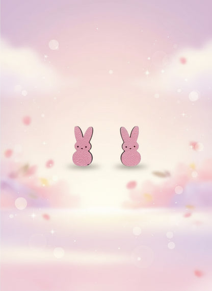 Pink bunny-shaped earrings on a black card with a wooden stand against a white background