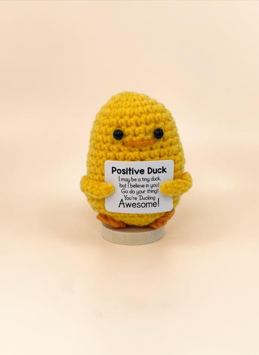 Emotional support duck plushie holding a sign that says 'You’re Ducking Awesome!' for encouragement.