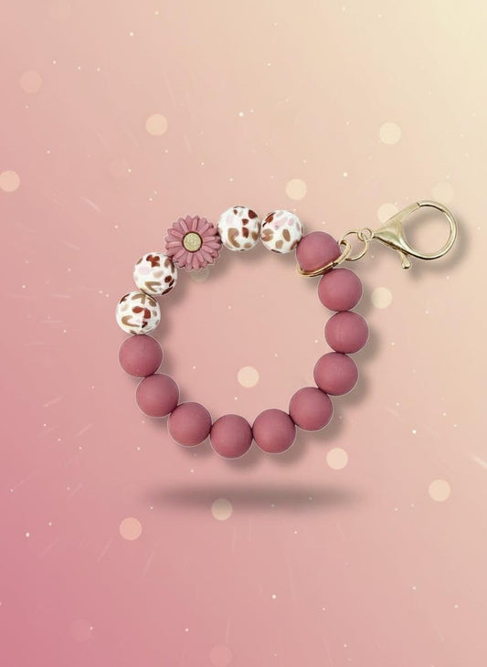 Pink beaded keychain with a tag on a white background