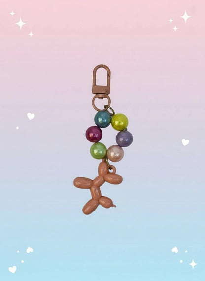 Colorful balloon dog keychain with beads on a white background