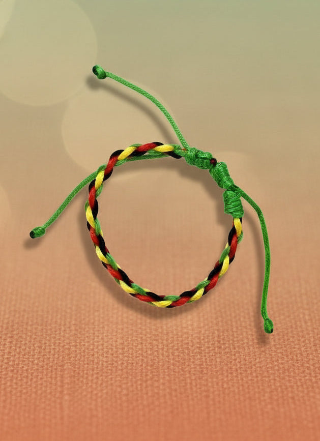 Rasta patterned bracelet on a cardboard backing against a white background