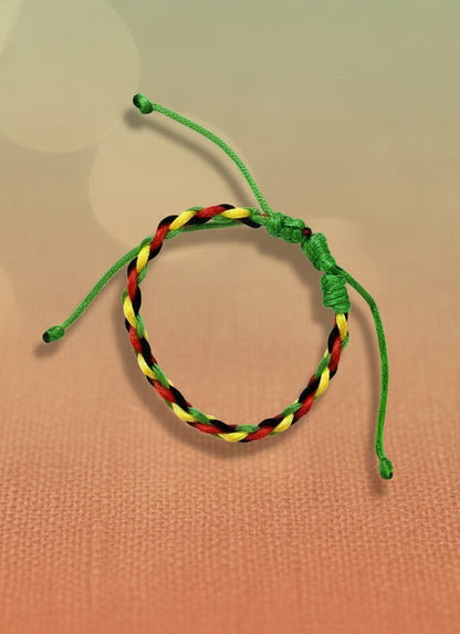 Rasta patterned bracelet on a cardboard backing against a white background