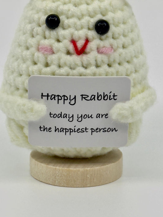 Crocheted rabbit with a card saying &#39;Happy Rabbit today you are the happiest person&#39; on a white background